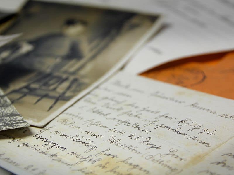 Een close-up van oude handgeschreven brieven en nostalgische zwart-witfoto's, die mij eraan herinneren om het leven in flow te leven.